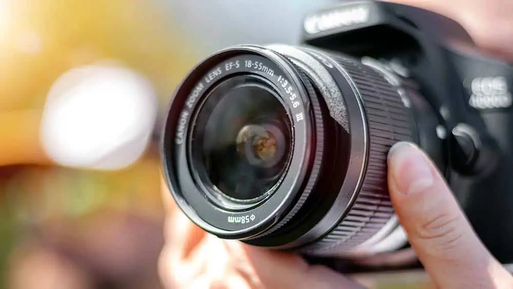 persoon maakt foto en zoomt met een spiegelreflexcamera
