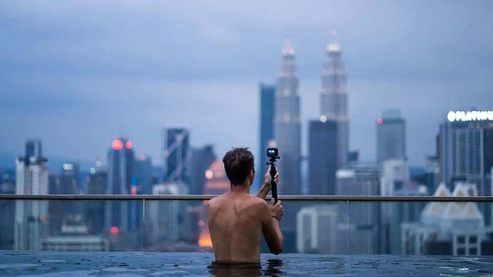 Man maakt foto van skyline vanuit zwembad met een action camera