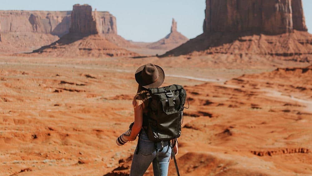 Vrouw in woestijn met een telelens camera