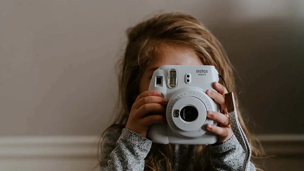 Klein meisje maakt foto met instax camera