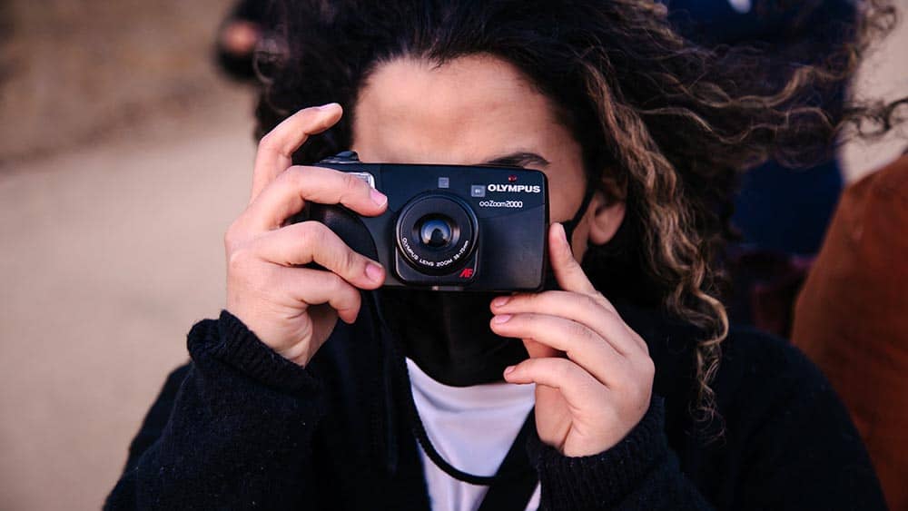 vrouw maakt een foto met een compactcamera