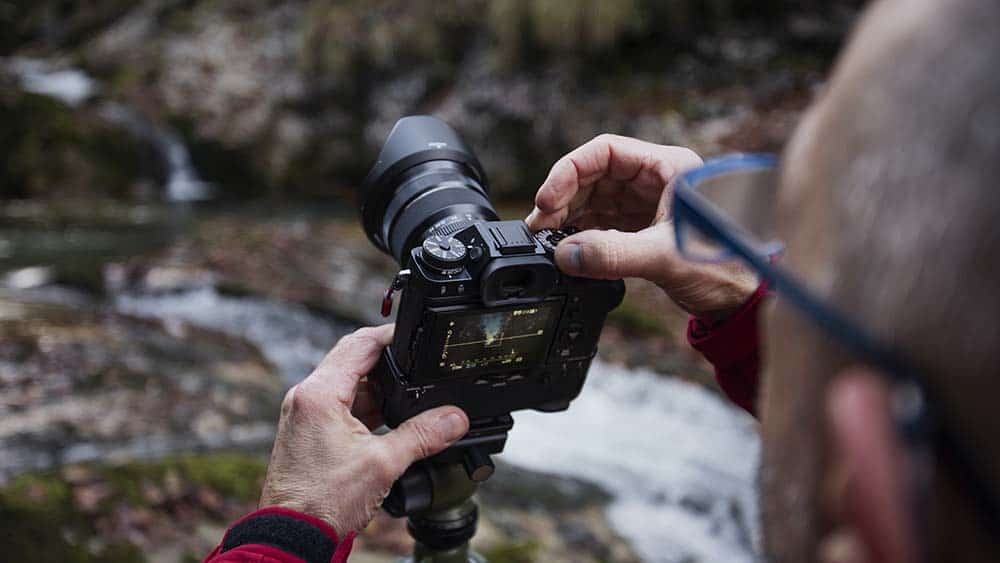 Man stelt systeemcamera in voor foto's in de natuur