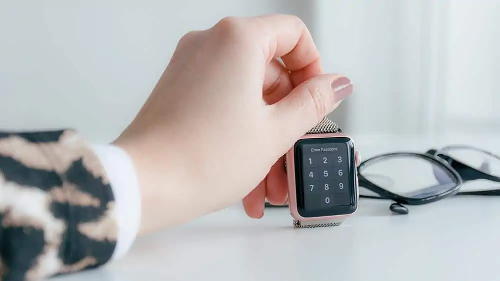vrouw heeft een roze smartwatch vast