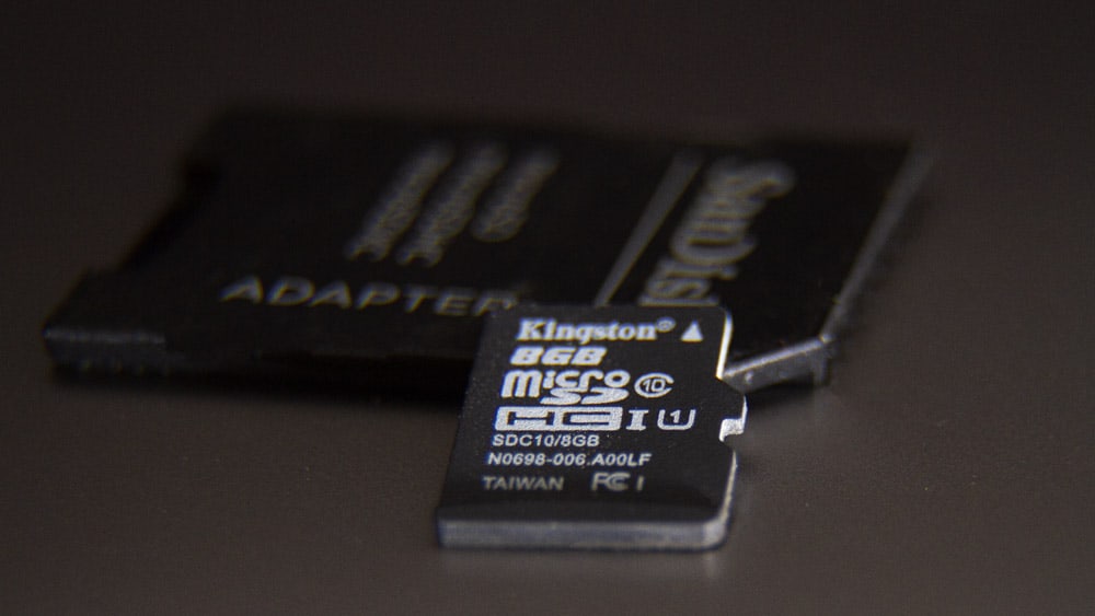 een microSD-kaart naast een SD-kaart adapter
