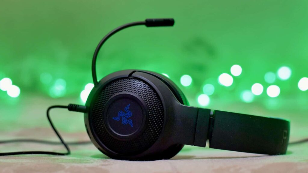 Een gaming-headset van Razer met de microfoon omhoog en groene lichtjes op de achtergrond.