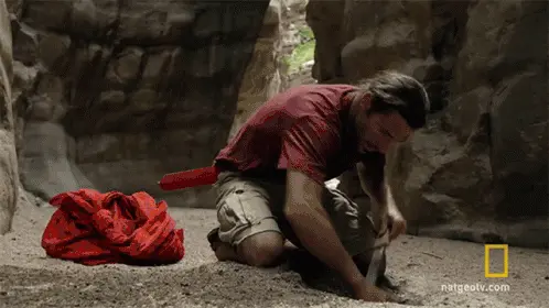 Een man die in een grot aan het graven is.