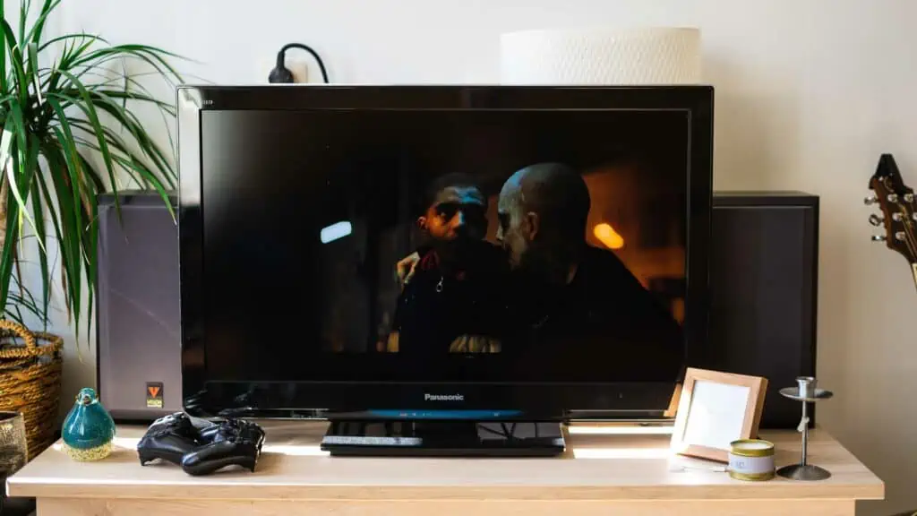 Een tv waarop een donkere scène uit een film te zien is.