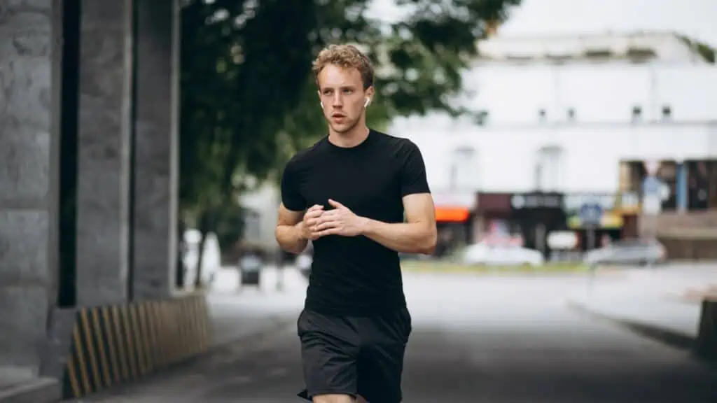 man gebruikt sport oordopjes tijdens hardlopen