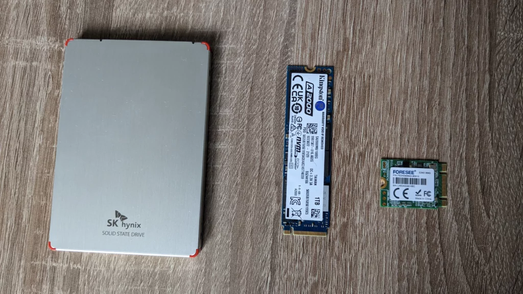 Drie soorten SSD die naast elkaar liggen: Een SATA-SSD, een NVME M.2 2280, en een NVME M.2 2230.