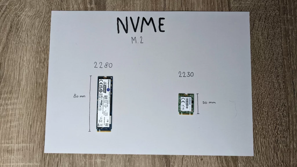 Een foto van twee NVME SSD's. Ze liggen op een papiertje en de namen en maten zijn met een zwarte stift aangegeven. Links ligt een 2280 M.2-SSD, en rechts een 2230 M.2-SSD. Aan de zijkanten staat aangegeven hoeveel milimeter (80 en 30 mm) lang ze zijn.