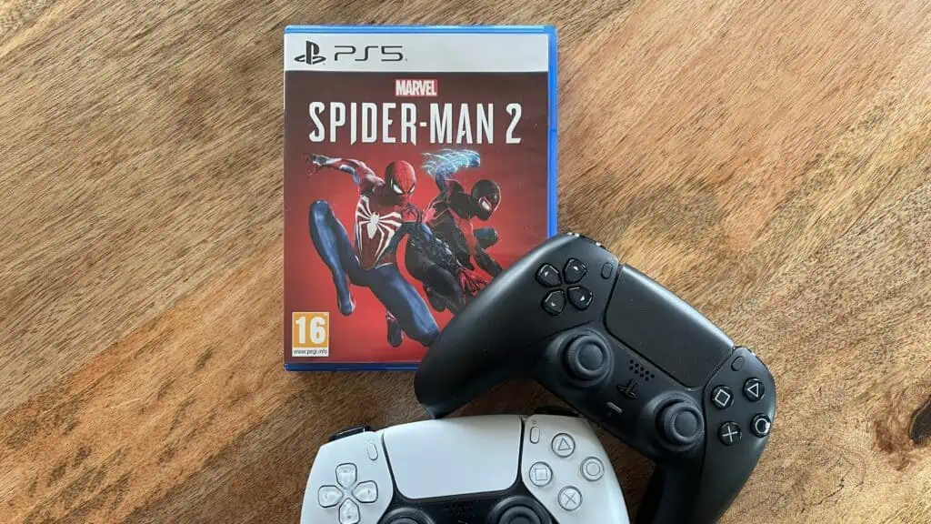 Ps5 game Spiderman met twee controllers eronder